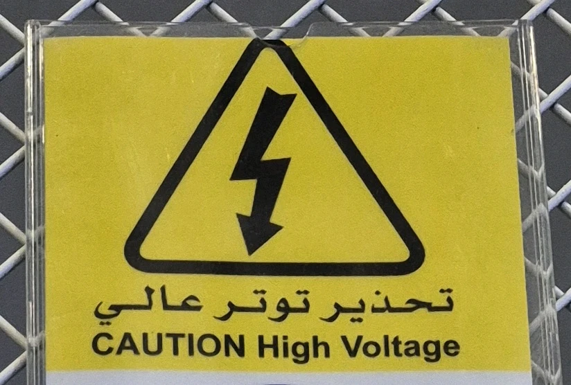 A warning sign that says "CAUTION High Voltage"
