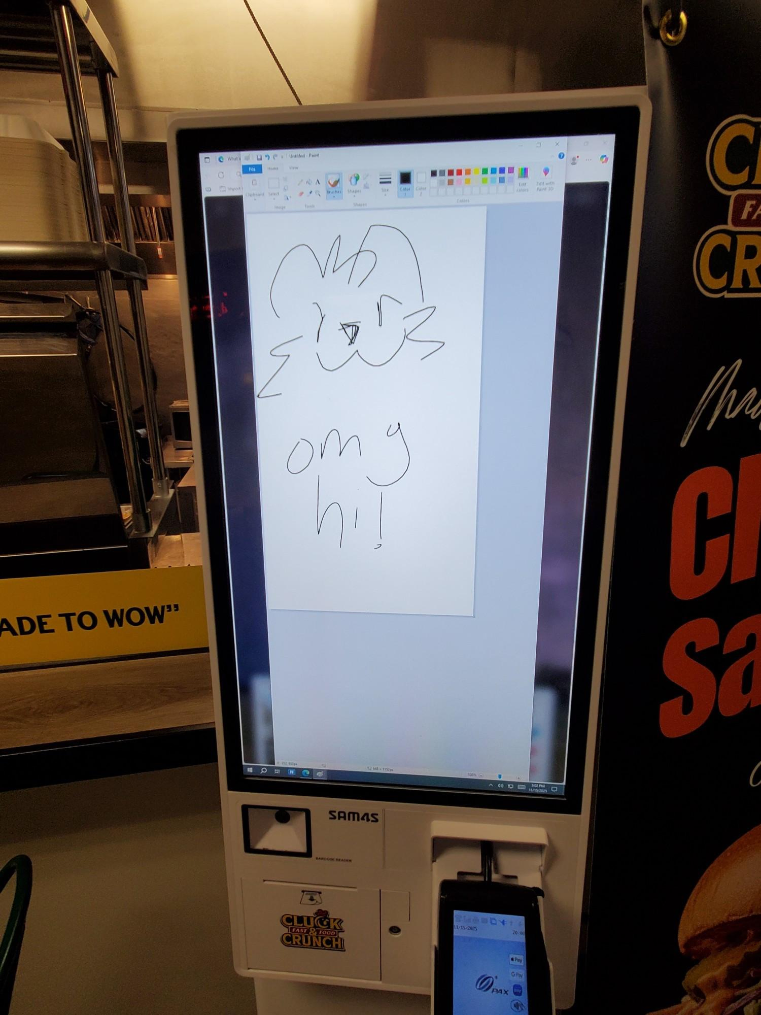 A picture of a several-feet-tall vertical kiosk. It has a sketched animal face at the top and "omg hi!" was written below.